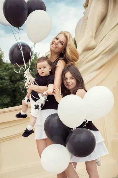 Mãe com filhos se divertindo com balões — Fotografia de Stock