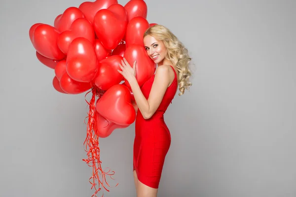 Linda mulher loira posando a sorrir e segurando balões — Fotografia de Stock