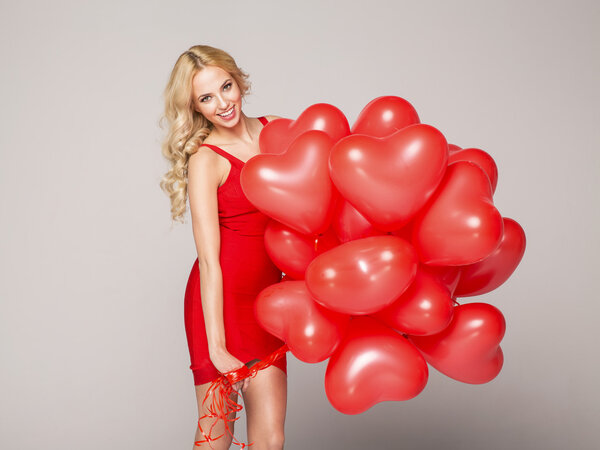 Beautiful blond woman posing and holding balloons