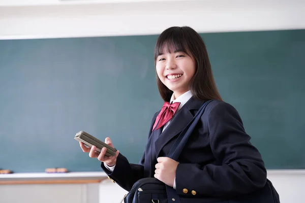 Bir Japon Ortaokul Öğrencisi Sınıfta Telefonunu Kullanırken Gülümsüyor — Stok fotoğraf