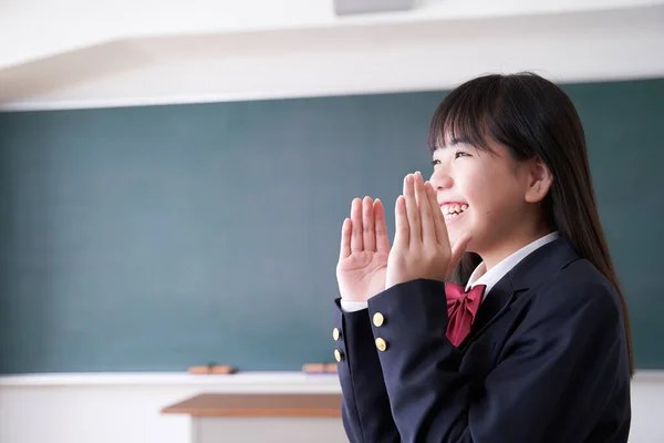A Japanese junior high school girl cheers in her classroom
