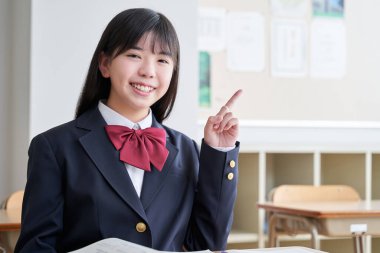 Japon bir ortaokul öğrencisi sınıfı işaret ediyor.