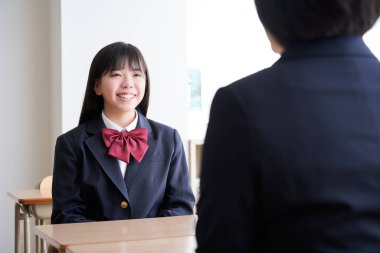 Japon bir ortaokul öğrencisi öğretmeniyle sınıfta buluşuyor.