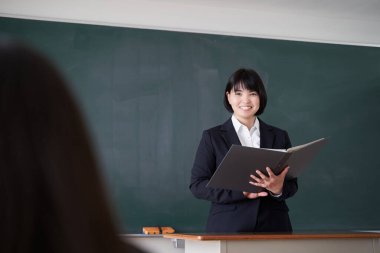 Bir Japon bayan öğretmen sınıftaki bir öğrenciye sorar