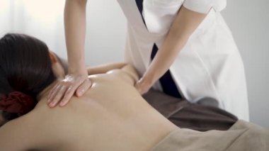 Japon kadın estetik bir salonda sırt masajı yaptırıyor.