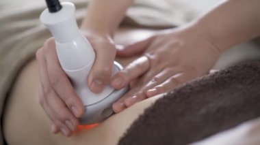 Japon kadın estetik bir salonda karnındaki selüliti ısıtmak için.