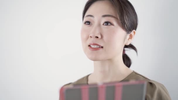 Japonský estetik dává konzultaci v salonu krásy pomocí tabletu - Stock záběr