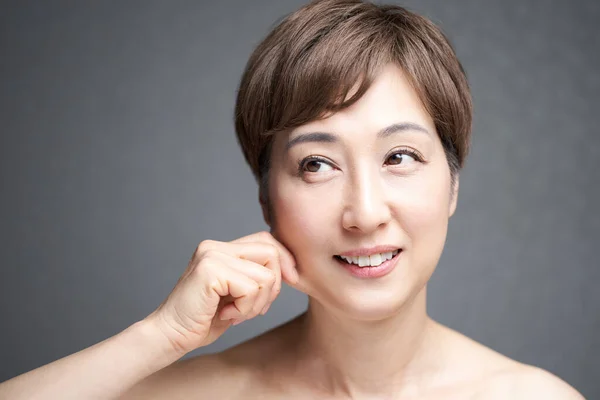 Orta yaşlı Japon kadın çene derisini yüzüyor