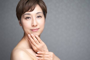 Orta yaşlı Japon kadın elini çenesine koydu.