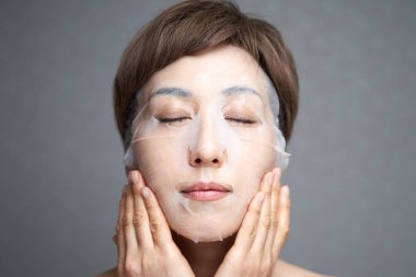 Orta yaşlı Japon kadın paket yapıyor.