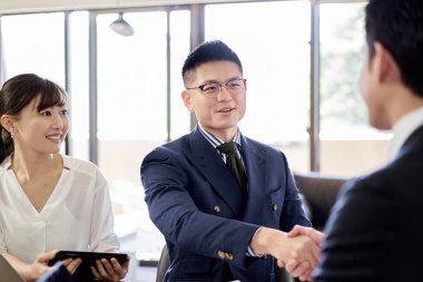 Asyalı işadamı Latince ile tokalaşıyor