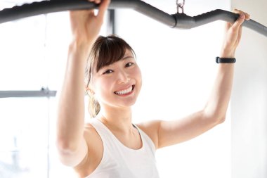 Asian woman pulling down a rat with a smile