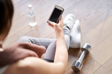 Asian woman watching training app on smartphone