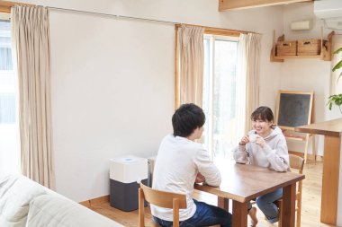 Asyalı çift oturma odasında sohbet ediyor.