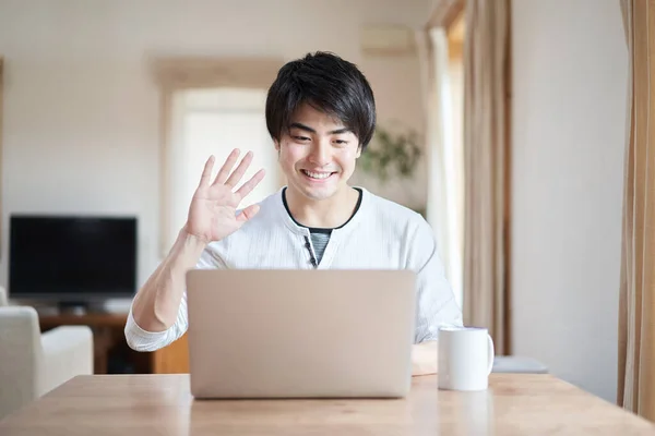 Asian man talking online with a smile