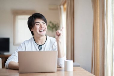 Bilgisayar kullanırken Asyalı bir adam işaret ediyor