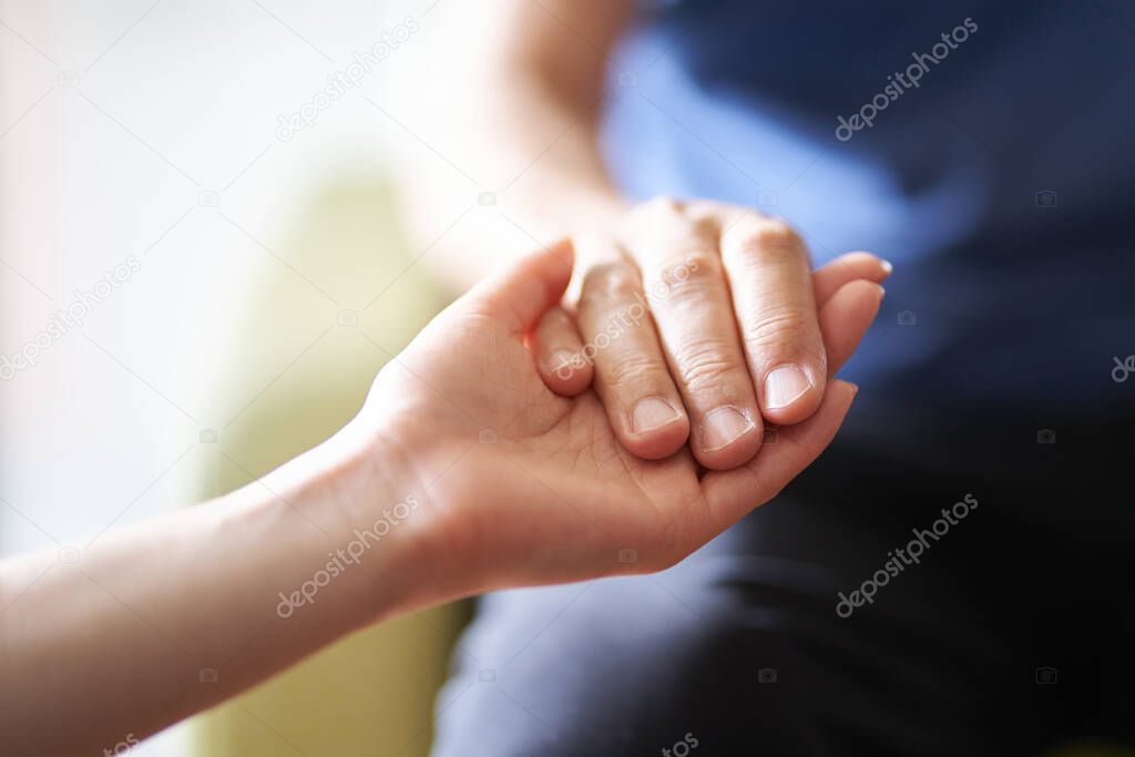 Hands of caregivers and the elderly