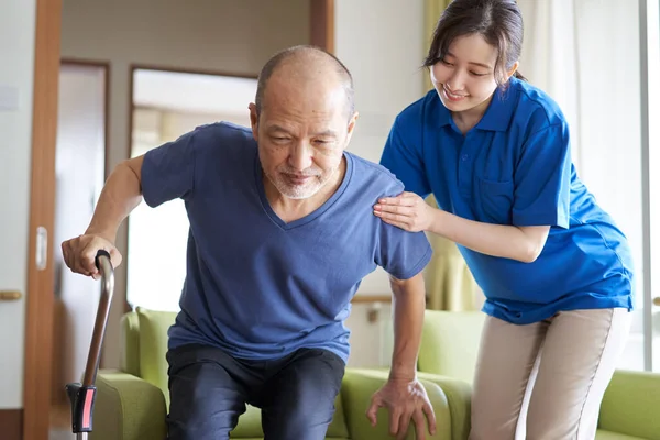 Eine Altenpflegerin Die Senioren Mit Einem Stock Hilft — Stockfoto
