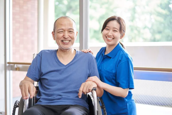高齢者や介護者に乗る車椅子 — ストック写真