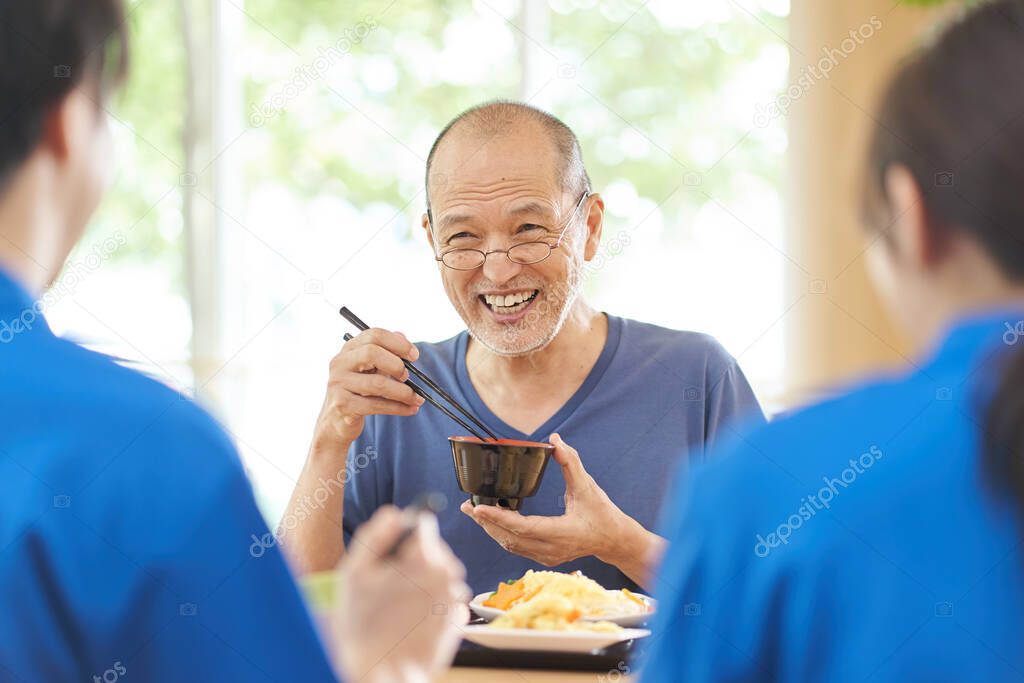 Elderly people having fun eating at a long-term care facility