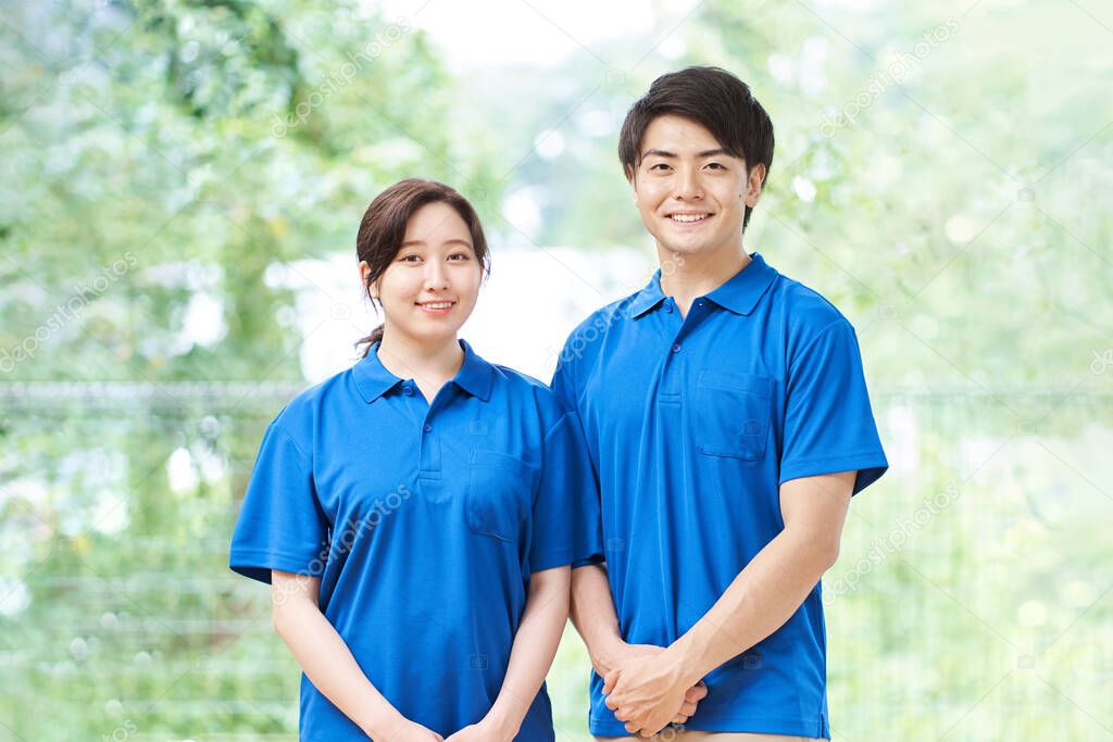 Male and female caregivers standing on a green background