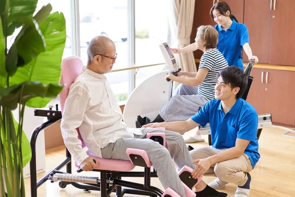 介護施設のフィットネスコーナーで運動する高齢者 — ストック写真