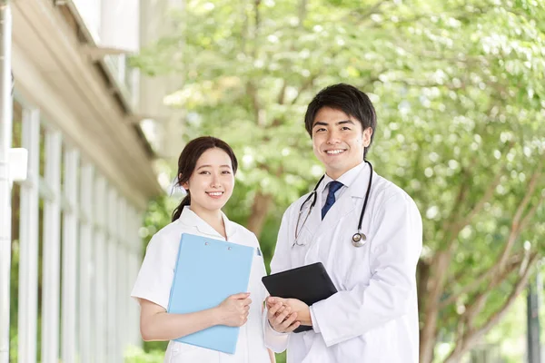 Γιατροί Και Νοσοκόμες Στέκονται Χαμόγελο Πράσινο Φόντο — Φωτογραφία Αρχείου