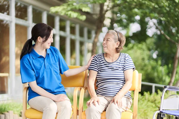 Cuidador Que Habla Con Los Ancianos Con Una Sonrisa —  Fotos de Stock