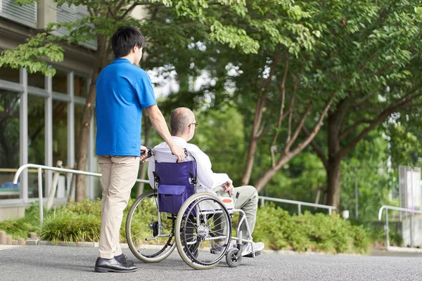 Altenpfleger Unterstützt Senioren Rollstuhl — Stockfoto