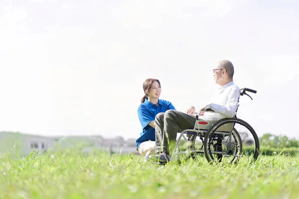 Senioren Und Betreuer Unterhalten Sich Auf Dem Rasen — Stockfoto