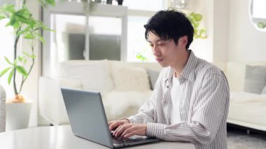 Bilgisayarda yazan Asyalı adam
