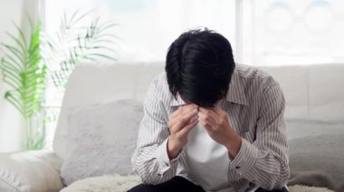 Kanepede depresif bir Asyalı var.