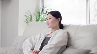 Kanepede uzanan Asyalı kadın.