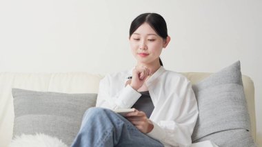 Asyalı kadın evde fikirleri not alıyor.