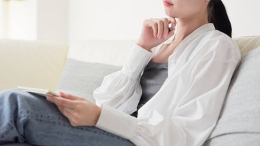 Asyalı kadın evde fikirleri not alıyor.