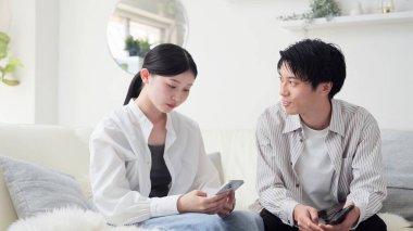 Asyalı çift akıllı telefondan tartışıyor.
