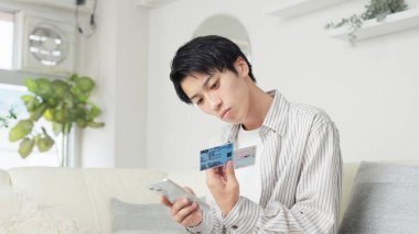 Asyalı adam Myna sağlık sigortası kartını hazırlıyor.