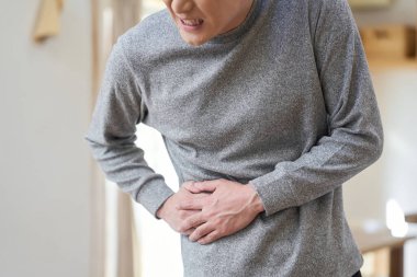 Asyalı adam acı çekiyor.