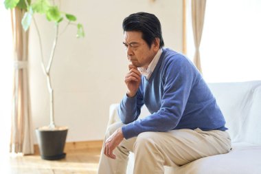 Asyalı son sınıf öğrencisi odasında endişeli.