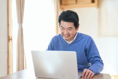 Bilgisayar kullanan kıdemli bir Asyalı.