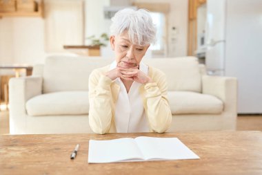 Asyalı son sınıf öğrencisi kadın oturma odasında dirseklerinin üzerinde dinleniyor.
