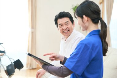 Evde bakıcılık yapan bir bakıcı tablet kullanır.