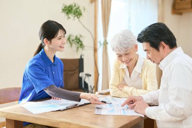 Asyalı bakıcı evde bakım sırasında planı açıklıyor