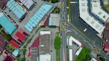 Malezya 'daki şehir caddelerinin, binaların ve trafik kavşağının yukarıdan aşağı görüntüsü, şehir planlamasını ve renkli çatıları gösteriyor.