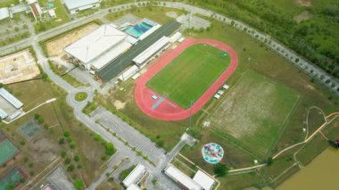 Koşu pisti, futbol sahası, kapalı alan ve iyi planlanmış bir eğlence alanı içindeki tesislerin yer aldığı modern bir spor kompleksinin havadan görünüşü.
