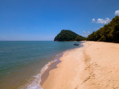 Pantai Bukit Keluang, Besut, Terengganu 'nun hava manzarası turkuaz suları, kıyı kayalıkları ve kıyı şeridi boyunca güneşli gökyüzünü gösteriyor..