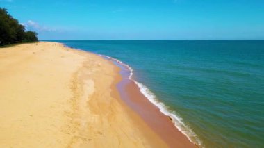 Pantai Bukit Keluang, Besut, Terengganu 'nun hava manzarası turkuaz suları, kıyı kayalıkları ve kıyı şeridi boyunca güneşli gökyüzünü gösteriyor..