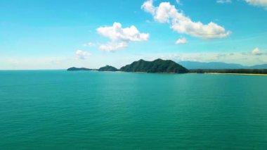 Pantai Bukit Keluang, Besut, Terengganu 'nun hava manzarası turkuaz suları, kıyı kayalıkları ve kıyı şeridi boyunca güneşli gökyüzünü gösteriyor..