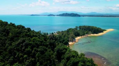 Pantai Bukit Keluang, Besut, Terengganu 'nun hava manzarası turkuaz suları, kıyı kayalıkları ve kıyı şeridi boyunca güneşli gökyüzünü gösteriyor..