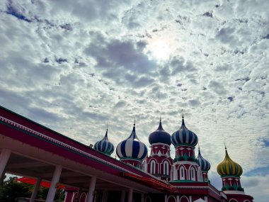 Rawang, Selangor, Malezya - 27 Kasım 2025 - Besut, Terengganu 'daki Masjid Lapan Kubah, parlak mavi gökyüzü altındaki renkli kubbeler.